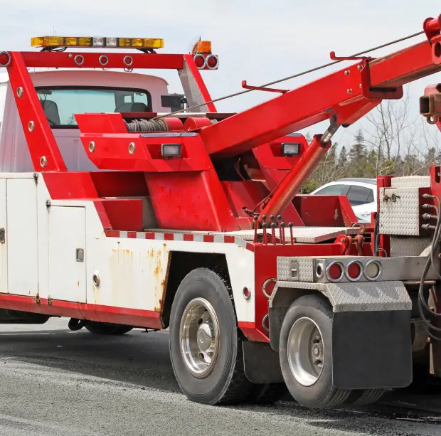 Red tow truck on the roadside.