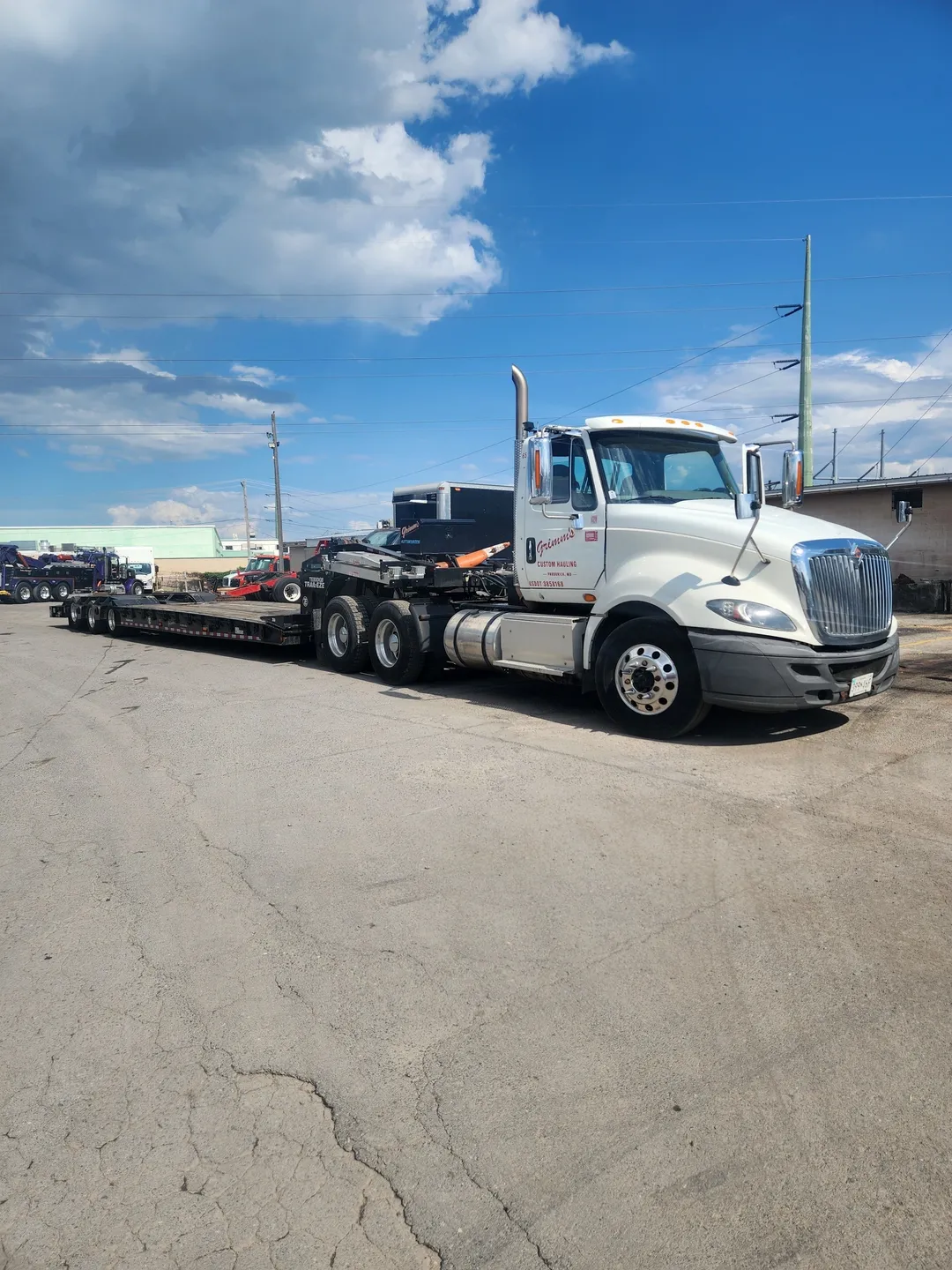 A white semi truck with a trailer on the back.