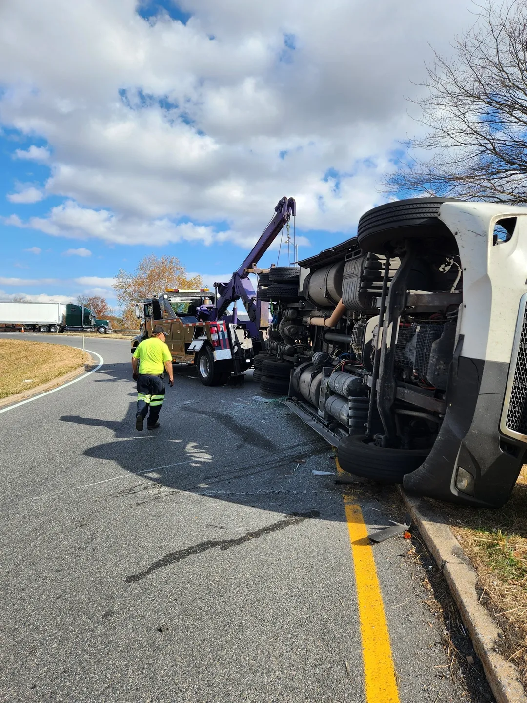 A truck that has been overturned on the side of the road.